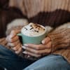 Frau hält Tasse mit Heißgetränk