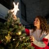 Frau schmückt Weihnachtsbaum