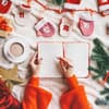 Person schreibt in weihnachtliches Buch