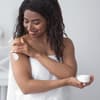 Frau trägt Bodylotion auf