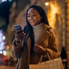 Frau schaut erfreut aufs Handy