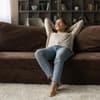 Junge Frau auf Sofa in kleiner Wohnung