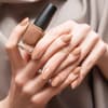 Person hält braunen Nagellack