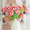 Frau drappiert Blumen in Vase