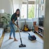 Frau saugt das Wohnzimmer