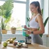 Frau mixt sich Shake nach Sport