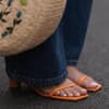Orange Sandalen und Korbtasche