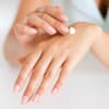 Frau trägt sich Creme auf Hand auf Handcreme Bodylotion