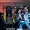 Gruppe von Freunden guckt Fernsehen und erschreckt sich