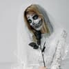 Frau im Braut-Halloween-Kostüm als Skelett geschminkt
