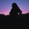 Silhouette einer Frau mit langen Haaren in der Nacht