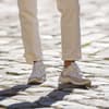 Frau trägt beige-weiße Sneaker mit Plateau-Sohle