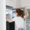 Frau öffnet Gefriertruhe