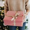 Person mit Geschenk in der Hand