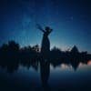 Schattenbild einer Frau an einem See in der Nacht