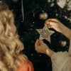 Frauen schmücken Weihnachtsbaum mit Stern