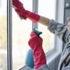 Frau putzt Fenster