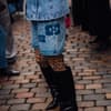 Frau trägt auf Copenhagen Fashion Week Jeans Kombi und Leomuster Strumpfhose und spitze schwarze Stiefel
