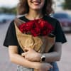 Frau hält einen Strauß mit roten Rosen in der Hand