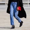 Frau trägt rote Tasche und Jeans