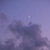 Halbmond am lilafarbenen Himmel mit Wolken