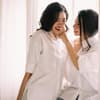 Zwei lächelnde Frauen mit schwarzen Haaren 