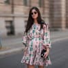 Schwangere Frau im rosanen Kleid mit Sonnenbrille