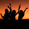 Drei Silhouetten von Frauen vor Sonnenuntergang