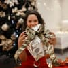 Frau mit Weihnachtsgeschenk in der Hand