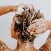 Frau shampooniert ihre Haare