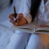 Frau schreibt in ihren Journal