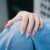 Eine Hand mit einer kreativen blauen Maniküre