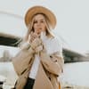 Frau mit Hut und Trenchcoat