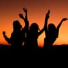 Drei Frauen tanzen unter dem Abendhimmel