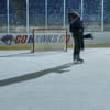 Ein Mann und eine Frau fallen sich auf einem Eishockeyfeld in die Arme.