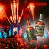 Eine Festivalbühne mit Feuerwerk und vielen Menschen davor, außerdem zwei Flaschen von Don Papa Rum darübergelegt.
