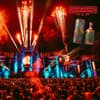 Eine Festivalbühne mit Feuerwerk und einer Menschenmenge davor.