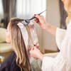 Eine Frau färbt ihre Haare beim Friseur