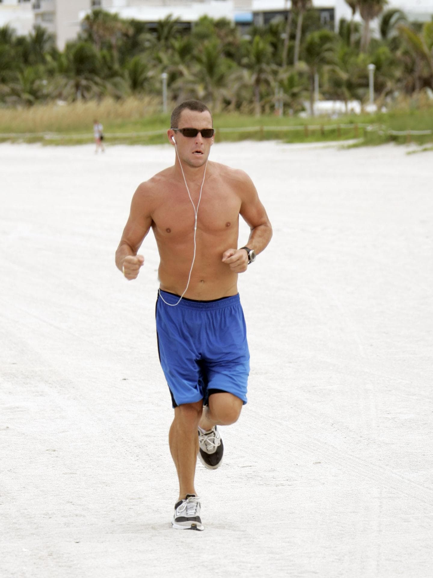 Lance Armstrong oberkörperfrei beim Joggen am Strand