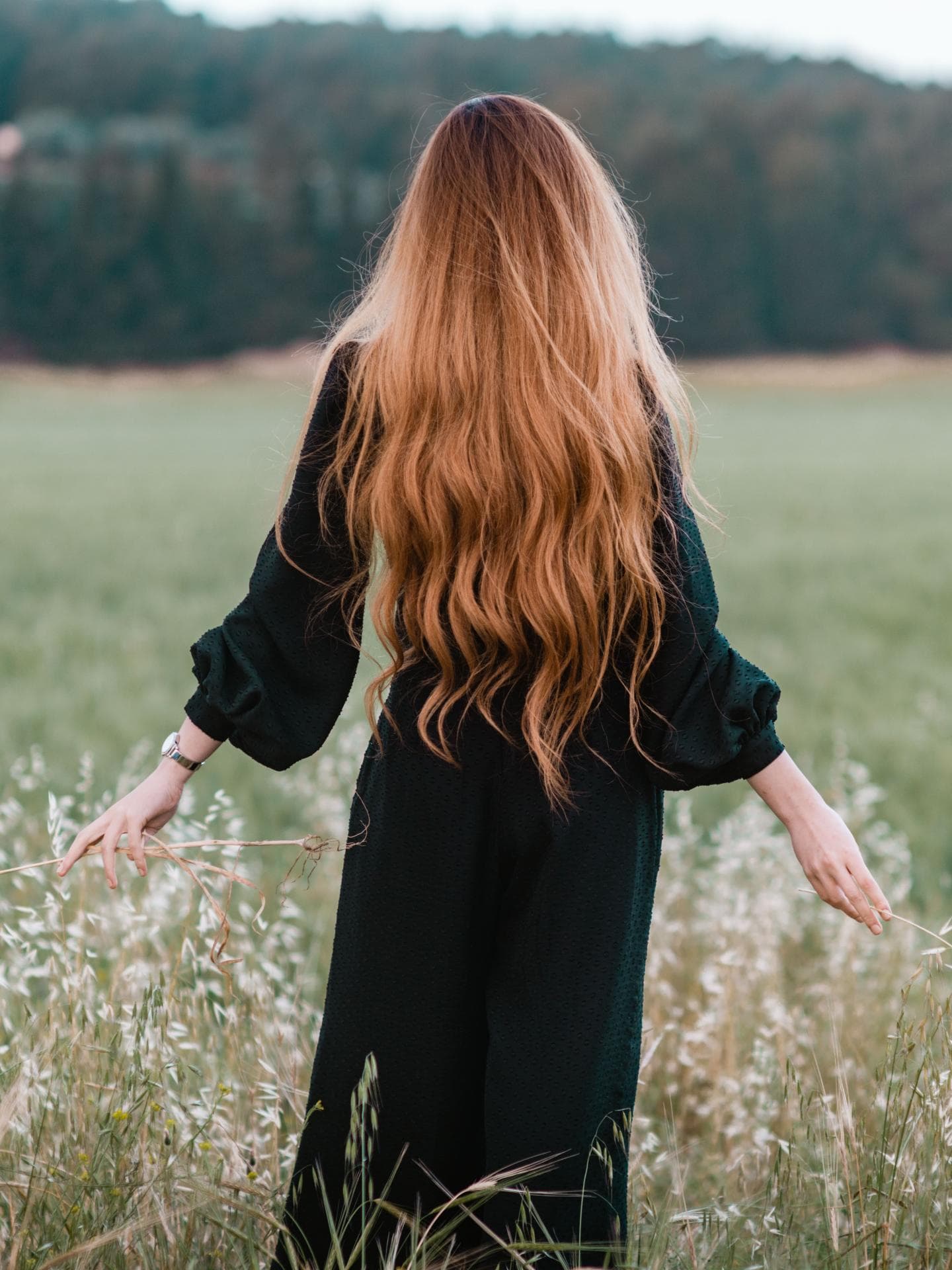 Frau mit langen Haaren auf einer Wiese