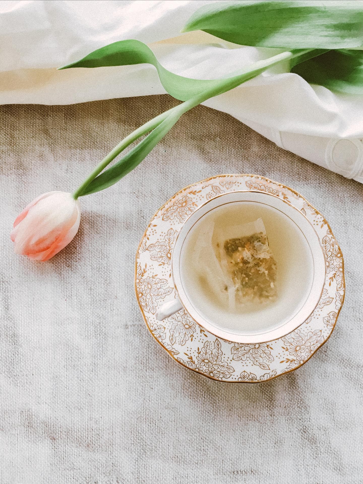 Kräutertee auf dem Tisch mit Tulpen