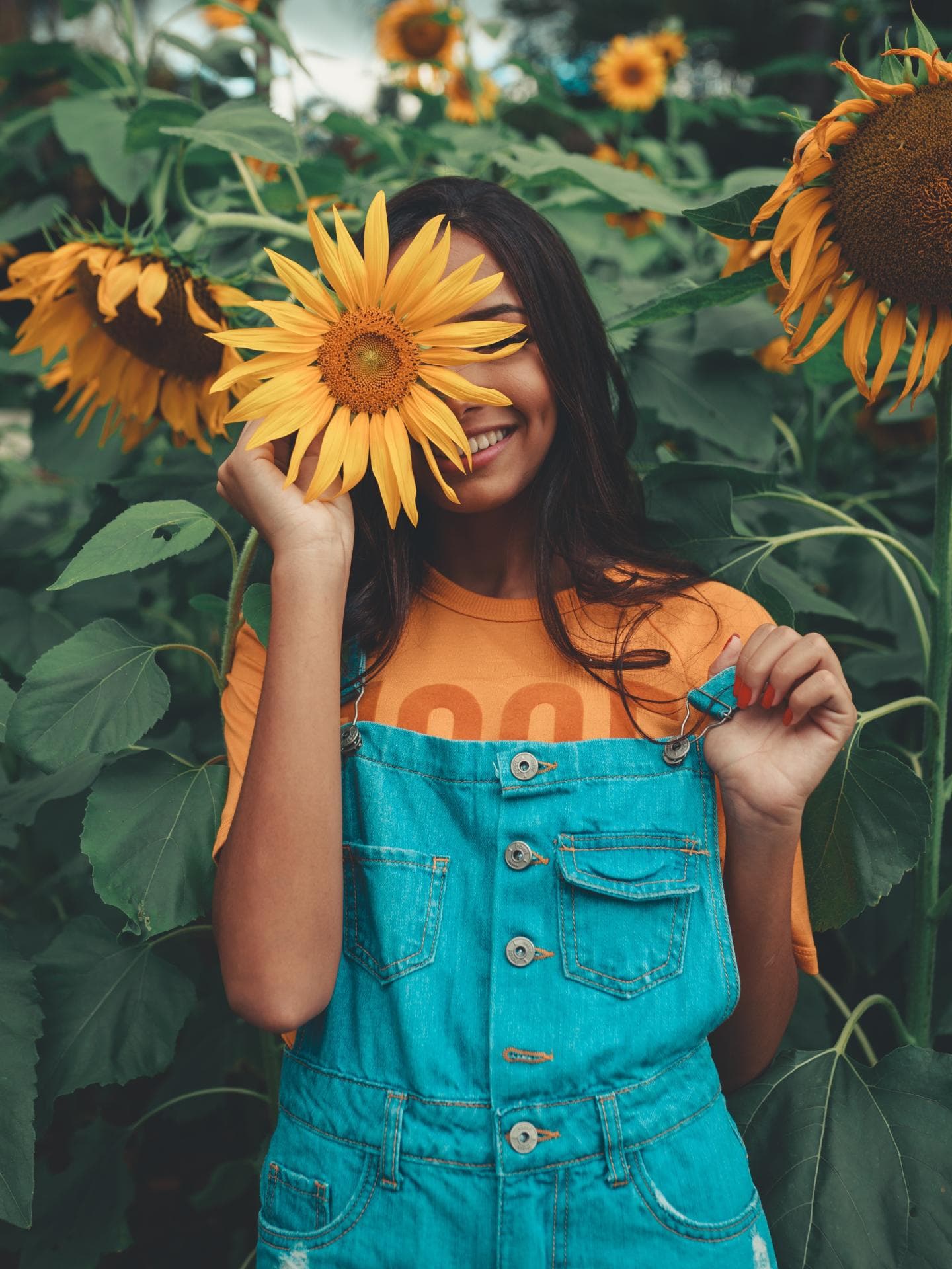 Horoskop: Frau mit Sonnenblume vor dem Gesicht