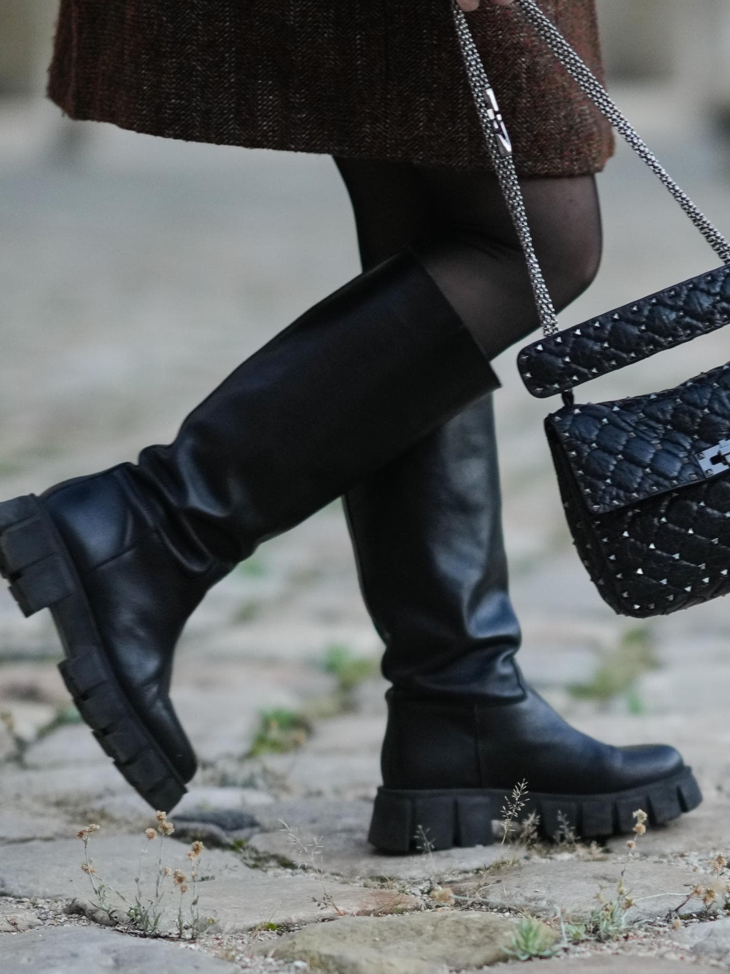 Frau trägt Stiefel mit Handtasche