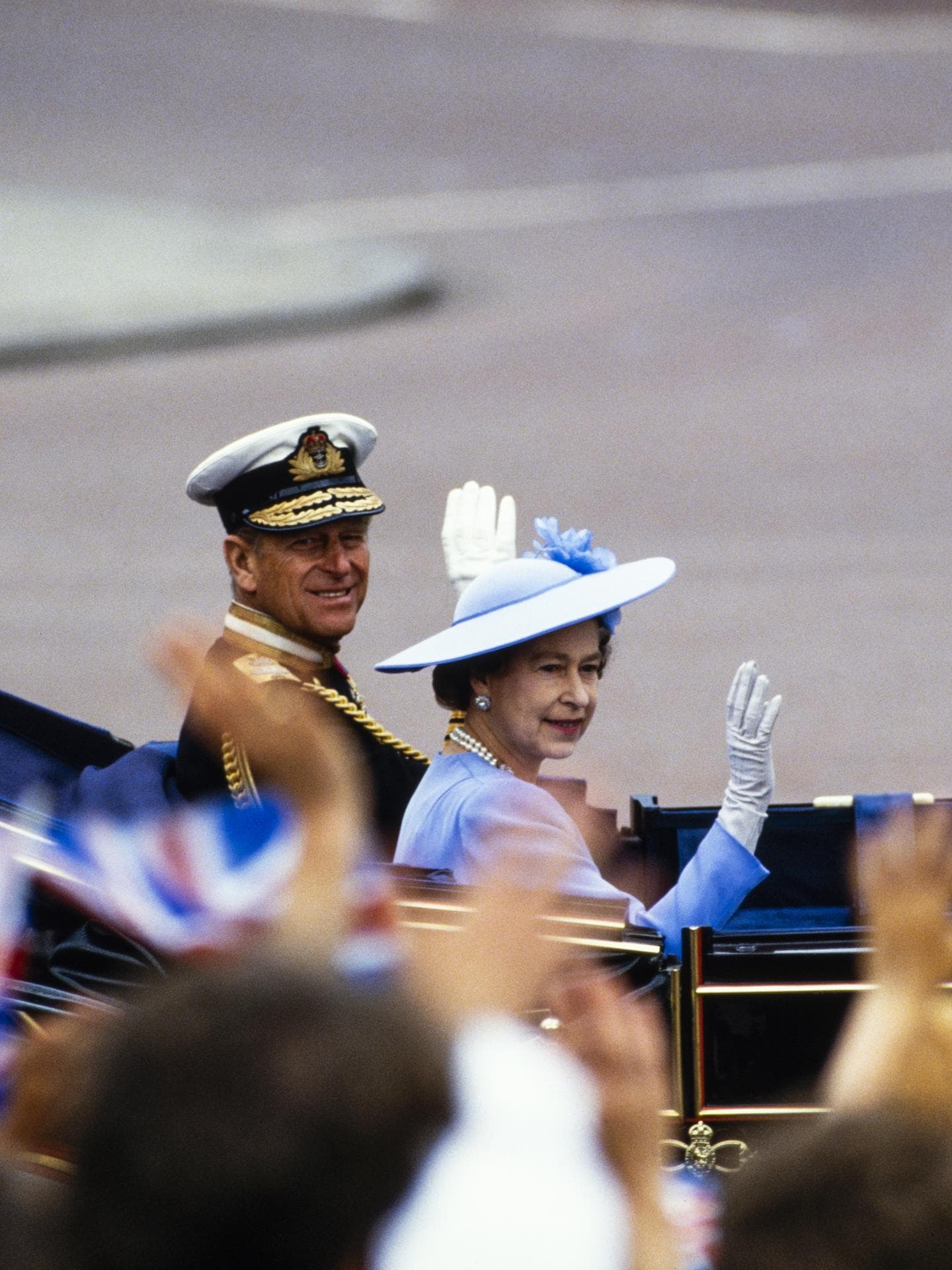Queen Elizabeth und Prinz Phillip sitzen in einer Kutsche und winken