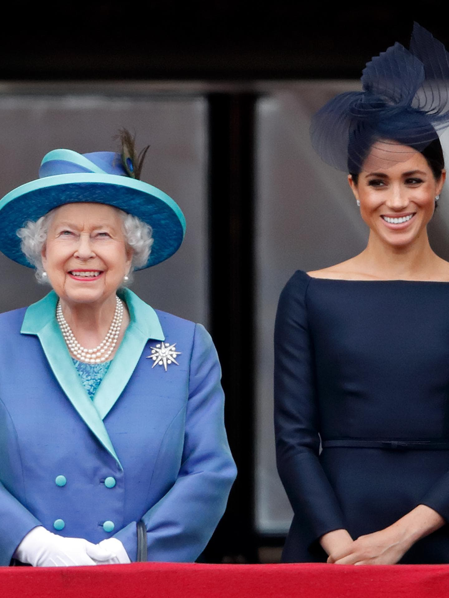Queen und Meghan Markle stehen nebeneinander auf einem Balkon