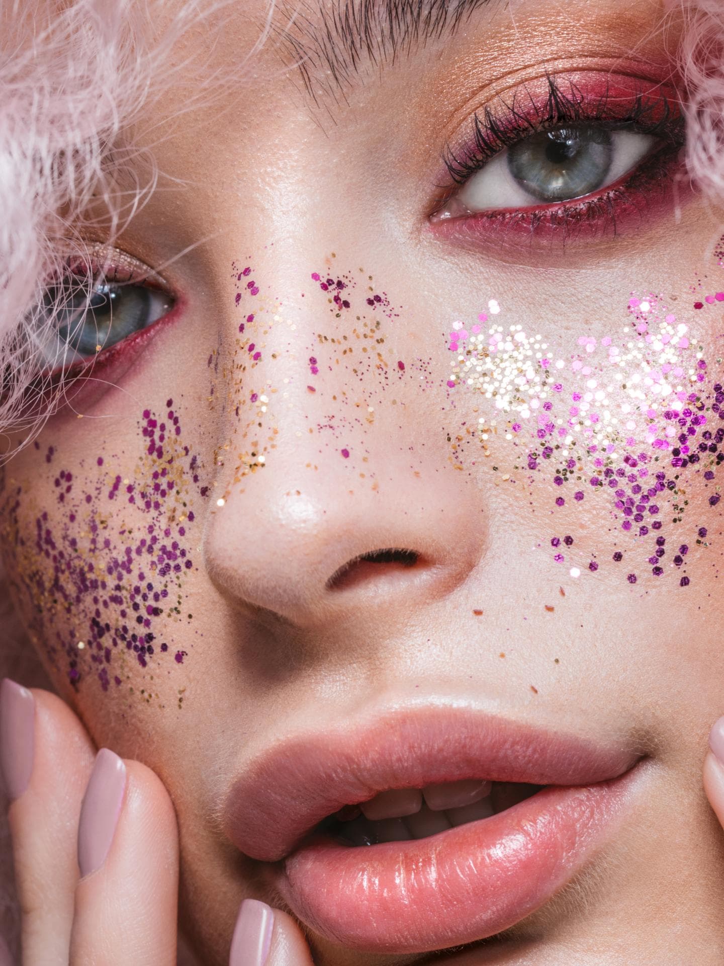 Frau trägt Glitzer-Partikel im Gesicht als Make-up