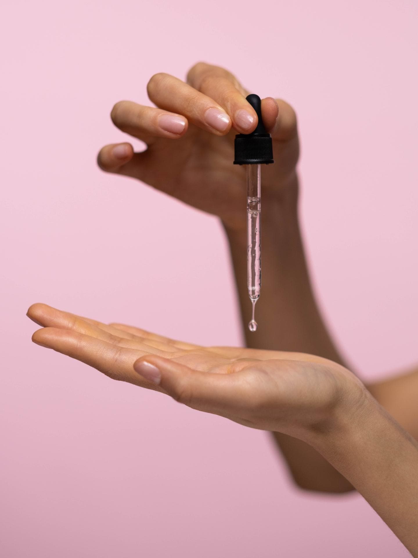 Hände tragen Serum auf