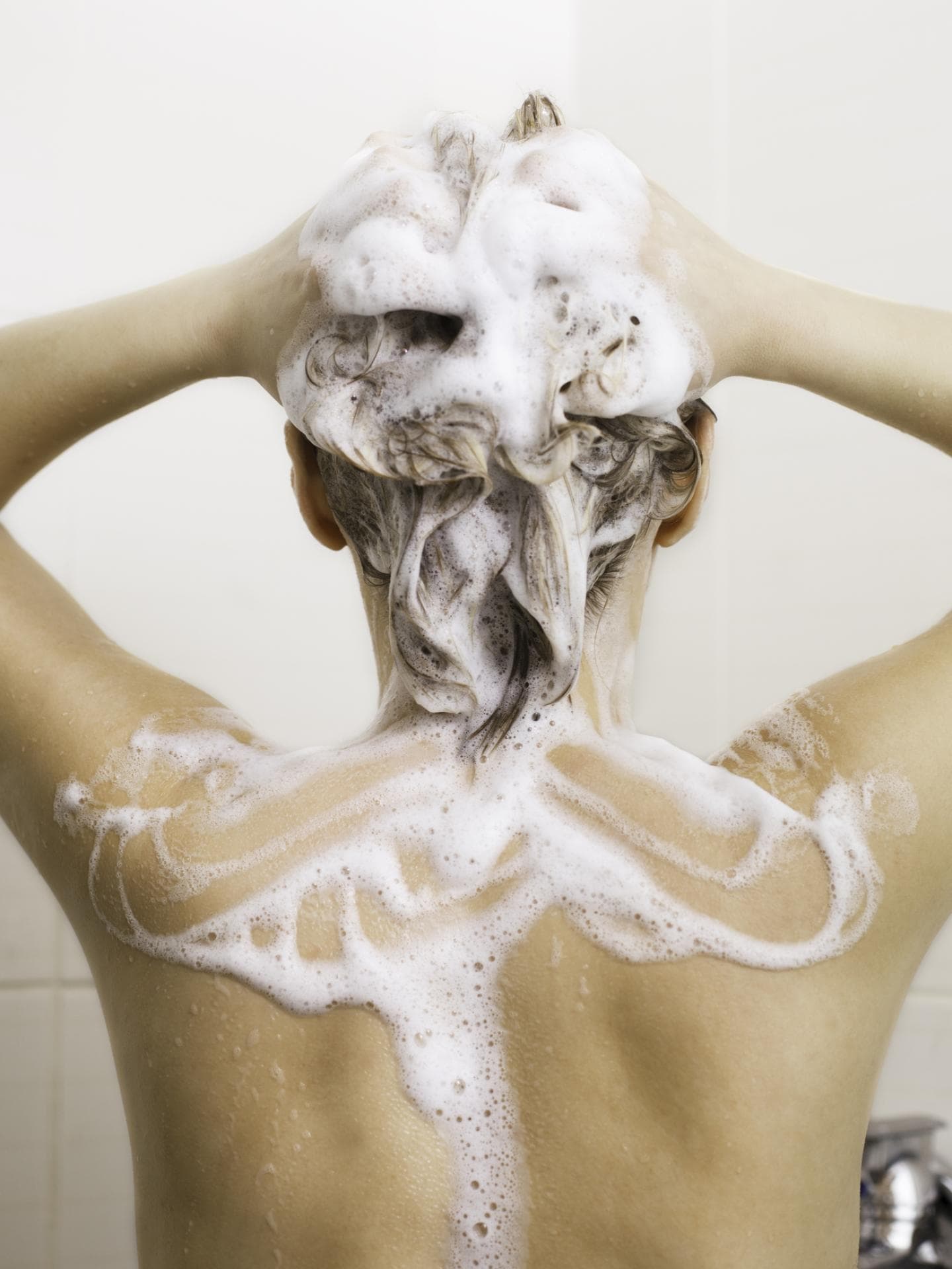 Frau wäscht sich die Haare
