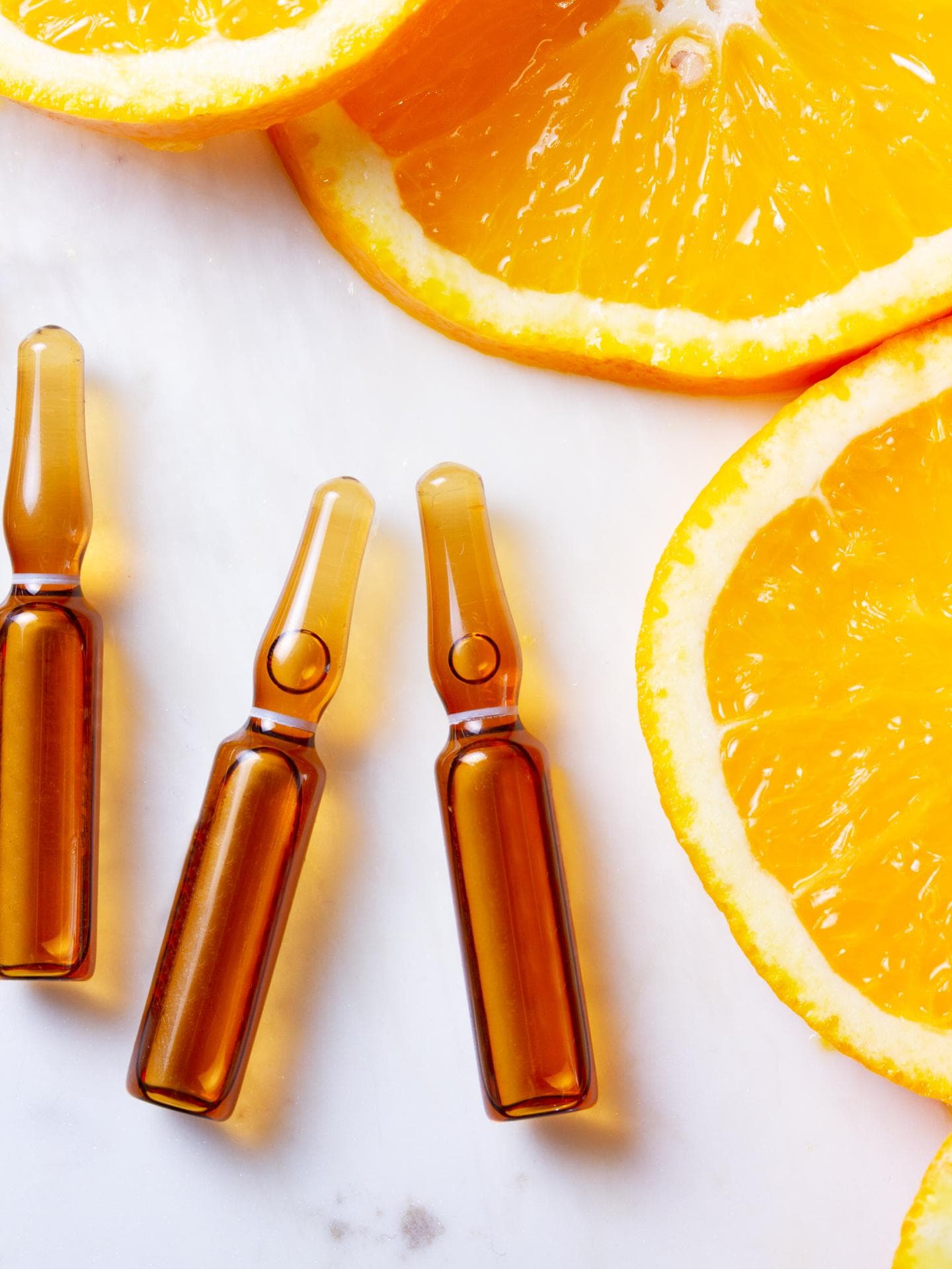 Vitamin C Seren Flakons neben Orangenscheiben