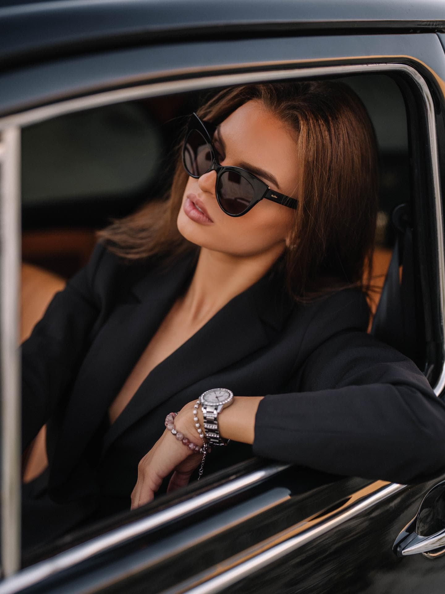 Frau mit Sonnenbrille sitzt im Auto